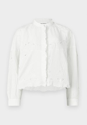 Fehér blúz fodros gallérral, hosszú ujjakkal és gombos záródással. Virágos hímzéssel és rövid, texturált dizájnnal.