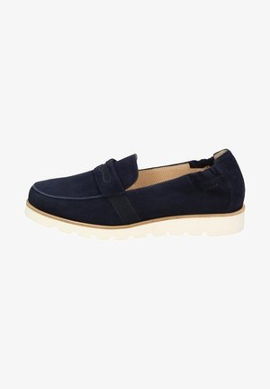 Mocassin en daim bleu marine avec une semelle blanche, un détail élastique au dos et une doublure intérieure beige perforée.