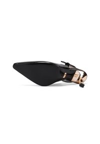 Scarpa con tacco alto in pelle verniciata nera, punta affilata, fiocco decorativo sulla cinghia alla caviglia e un accento dorato lucido vicino al tallone.