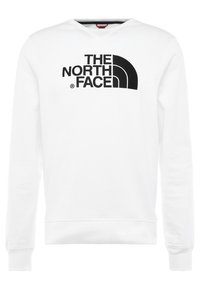 Vit långärmad hoodie med svart "THE NORTH FACE"-logotyp centrerad på bröstet och en svart halvcirkel-design.