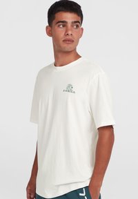 Light beige T-shirt with short sleeves, featuring a green wave graphic and "O'Neill" logo on the chest, made of soft cotton material.