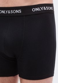 Black cotton boxer briefs with a wide elastic waistband displaying "ONLY&SONS" in white, featuring a fitted design and smooth texture.