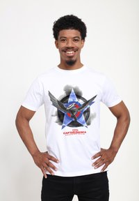 Camiseta blanca de algodón con un gráfico de un superhéroe alado, estrellas azules y rojas, un diseño circular y el texto "Capitán América".