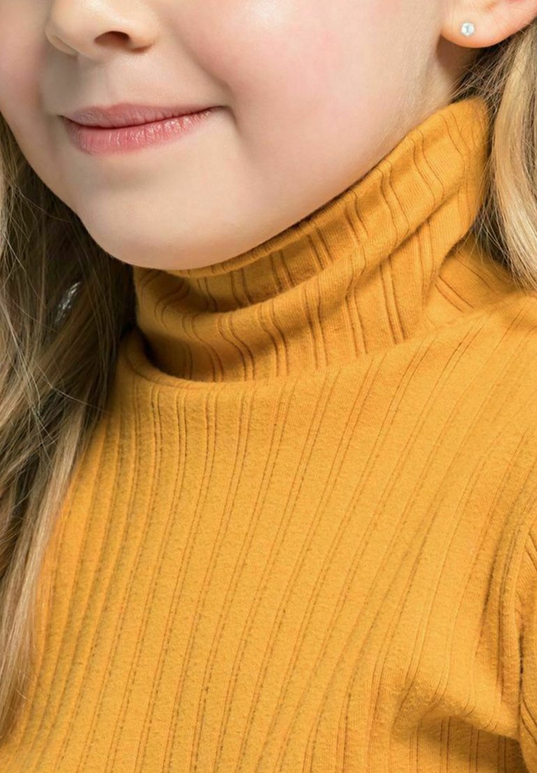 Maglione giallo senape con colletto alto a costine. Tessuto morbido, finitura liscia e sottili righe verticali. Capelli parzialmente visibili.