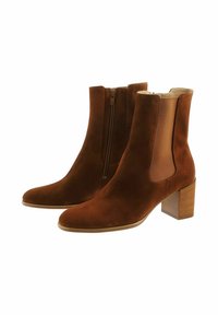 Bottines en daim marron avec une finition lisse, fermeture éclair latérale et panneaux élastiques, dotées d'un talon en bois rectangulaire.