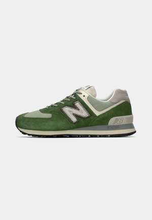 Sneaker New Balance verde e beige in materiali scamosciato e mesh, con allacciatura frontale e intersuola ENCAP ammortizzata, vista laterale su sfondo bianco.