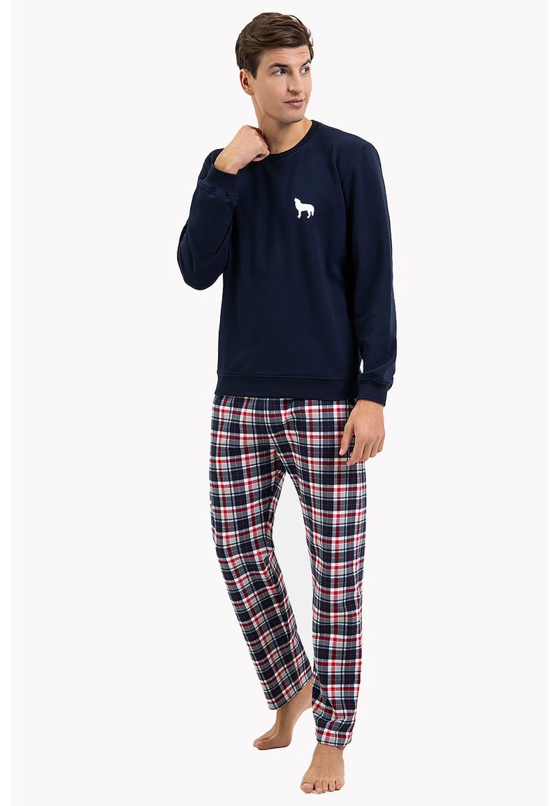 Granatowa bawełniana bluza z białym nadrukiem psa, zestawiona z bawełnianymi spodniami piżamowymi w kratę w kolorach czerwonym, granatowym i białym. Luźny krój.
