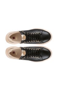 Černé kožené tenisky s hladkým povrchem, zlatými akcenty na patě a černými tkaničkami, s krémovou gumovou podrážkou a embosovaným logem.