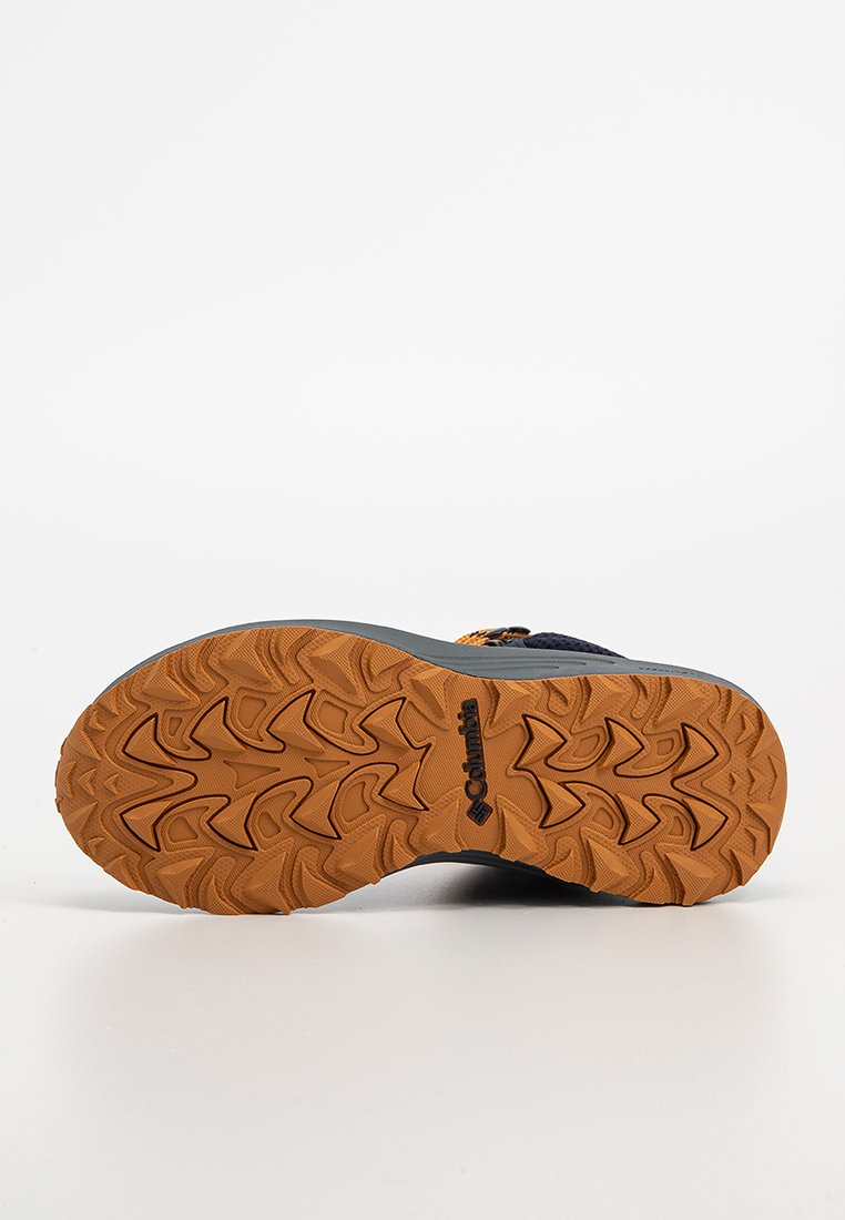 Columbia-Schuhe mit einer robusten Gummisohle in lebhaftem Orange, versehen mit einer strukturierten Grip-Oberfläche und einem geprägten Logo im Design.