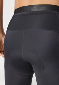 Shorts da ciclismo neri con un tessuto liscio e elastico, dotati di una sezione imbottita per il comfort. Il design include una vasta vita elastica e cuciture piatte.