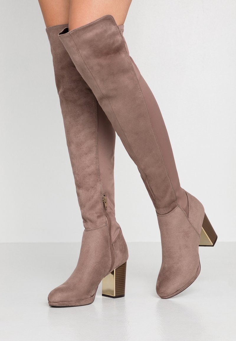 Botas hasta la rodilla de ante topo con tacón ancho brillante. Detalle de cremallera lateral y una combinación de tela suave y material liso.