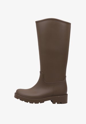 Bota alta de goma marrón con suela gruesa y punta redondeada, diseñada para uso en exteriores o en tiempo húmedo.