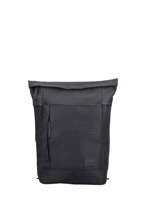 Sac à dos noir à rabat enroulable avec poche zippée à l'avant et écusson, en tissu résistant.