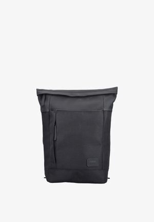 Sac à dos noir à rabat enroulable avec poche zippée à l'avant et écusson, en tissu résistant.