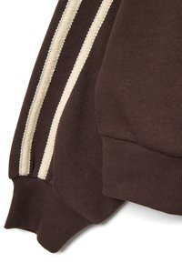 Sudadera marrón con acentos de canalé en color crema en las mangas y los puños, con un acabado de tela suave y texturizada.