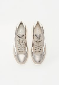 Grå og metallisk sølvfargede sneakers med suedes overflate, snøring, og kontrasterende hvite detaljer på sidene og tungen.