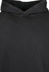 Sweat à capuche noir avec une texture de tissu lisse et une capuche légèrement repliée.