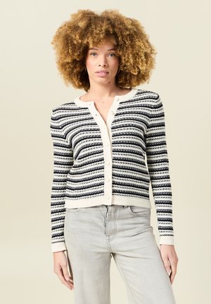Cárdigan de rayas en blanco y negro con botones de perla, que presenta un cuello y puños de canalé en color crema, fabricado en un material de punto suave.