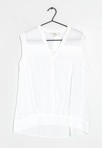 Witte mouwloze blouse met V-hals, voorzien van doorschijnende panelen op de schouders, een ronde zoom en lichte, gestructureerde stof.