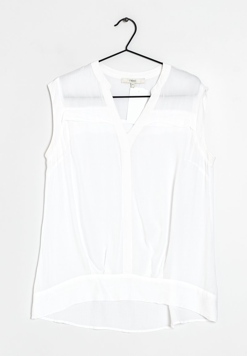 Biała bezrękawnik z dekoltem w serek, z przezroczystymi panelami na ramionach, zaokrąglonym dołem i lekkim, teksturowanym materiałem.