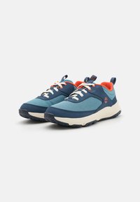 Blue athletic shoes with a mesh upper, contrasting orange accents, white laces, and a textured rubber sole. Low-profile design with a pull tab.