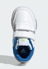 Balta ādas sporta apavi ar ziliem sietiņa akcentiem, diviem Velcro siksniņām un strukturētu zoli. Ievērojama zaļa logo detaļa uz mēles.