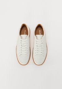 Baskets en cuir blanc avec une surface texturée, lacets plats, boîte à orteils perforée et semelle en caoutchouc beige. Logo "ALD" présent sur la semelle intérieure.