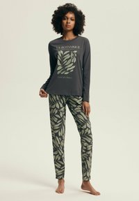 Piżama z długim rękawem w ciemnoszarym kolorze z zielonym nadrukiem liści; dopasowane spodnie mają ten sam wzór liści; wykonane z miękkiego materiału, luźny krój.