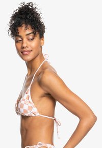 Driehoek bikini top in een perzik- en wit geruit patroon, met verstelbare strikbanden. Gladde stoftextuur en bloemenaccenten.