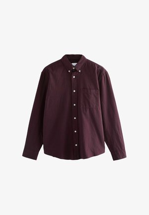 Chemise bordeaux à manches longues avec un col boutonné, dotée d'une poche sur la poitrine et de boutons blancs sur le devant. En coton, texture douce.