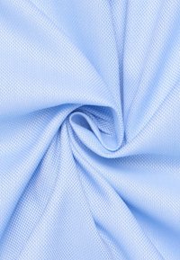 Tessuto testurizzato blu chiaro, caratterizzato da una superficie liscia con una leggera lucentezza e un motivo intrecciato, disposto a spirale.