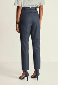 Marinblå randiga byxor med skräddarsydd passform, som har hög midja, bakfickor och en kortad benlängd som slutar vid ankeln.