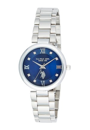 Orologio con cinturino in metallo argento, quadrante blu, numeri romani alle 12, 3, 6, 9, indicatori delle ore in cristallo, e logo e testo U.S. Polo Assn.
