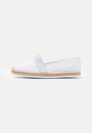 Hvid slip-on sko med vævet jutesål og iriserende strop mærket "JEANS" på ensfarvet hvid baggrund.
