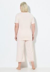 Světlé růžové pyžamo se short sleeve a zkrácenými kalhotami. Kalhoty mají krajkový lem na spodním okraji. Měkký, lehký materiál, volný střih.