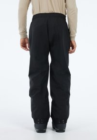 Zwarte waterdichte broek met een elastische tailleband, manchetten en verstevigde zomen. Glad materiaal en een rechte pijpontwerp voor bewegingsgemak.