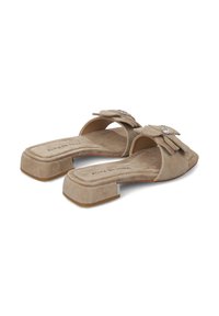Sandalias deslizantes de ante beige con punta cuadrada, detalle de lazo y acentos de strass en las correas; tacón cuadrado para mayor soporte y comodidad.
