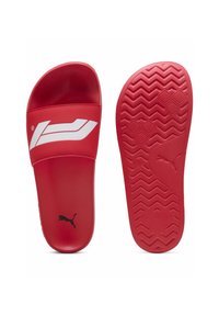 Des sandales à glissière rouges avec une tige lisse, arborant un logo blanc. La semelle texturée présente un motif en zigzag pour une meilleure adhérence.