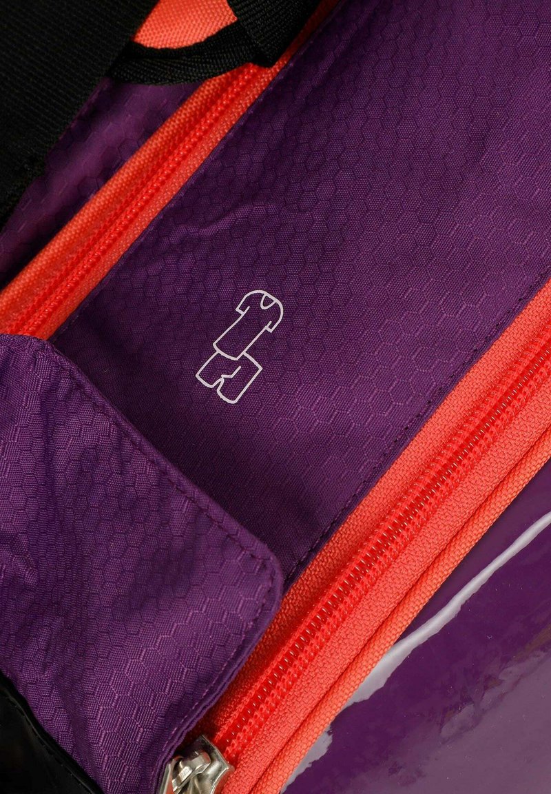 Purple fabric with red zipper and small white icon of folded t-shirt and shorts, indicating clothing compartment or section.