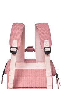Pink corduroy backpack featuring textured fabric, wide adjustable straps, and black hardware accents with a top handle for easy carrying.