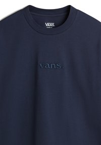 Camiseta de algodón de corte holgado en azul marino con cuello redondo. Presenta el logo bordado "vans." en un azul marino más oscuro en el frontal. Textura suave.