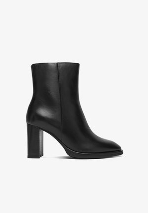 Schwarzer Leder-Stiefelette mit Blockabsatz und glatter Oberfläche, entworfen für Damenmode.