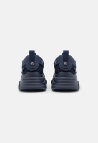 Navy blue sneakers with mesh and rubber materials, featuring a rounded shape, pull tab, and metal accent on the heel for easy wear.