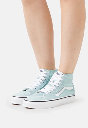 Zapatillas altas de ante de color azul claro con cordones blancos, suelas negras y logo lateral. Presentan acentos blancos en contraste y una tela texturizada.
