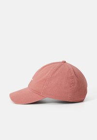 Boné de algodão rosa empoeirado com aba curvada e design de painéis costurados, apresentado de um ângulo lateral sobre um fundo branco.