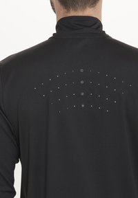 Sort sports langærmet skjorte med høj krave, der har et prikket ventilationsmønster og knapdetaljer på ryggen for luftcirkulation.