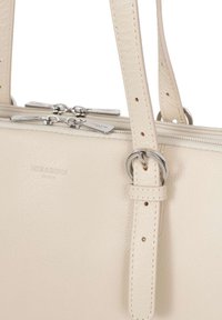 Borsa a mano in pelle beige con due cursori in metallo argentato, due manici con anelli metallici rotondi e cuciture visibili, caratterizzata da una superficie texture.