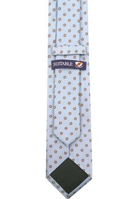 Lichtblauwe stropdas met een herhalend bruin bloemmotief, een donker groene punt en een label van het merk "Suitable". Gladde textuur.