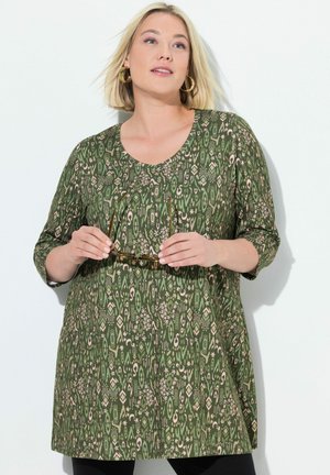 Groen gemuste tuniek met een ronde hals en driekwart mouwen. Kenmerkt zich door een mix van geometrische en bloemmotieven in crème.