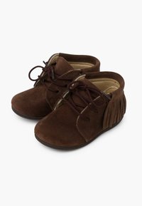 Botas de ante marrón hasta el tobillo con cordones marrones, con un detalle de flecos en el lateral y un interior suave y acolchado. Suela de goma plana.